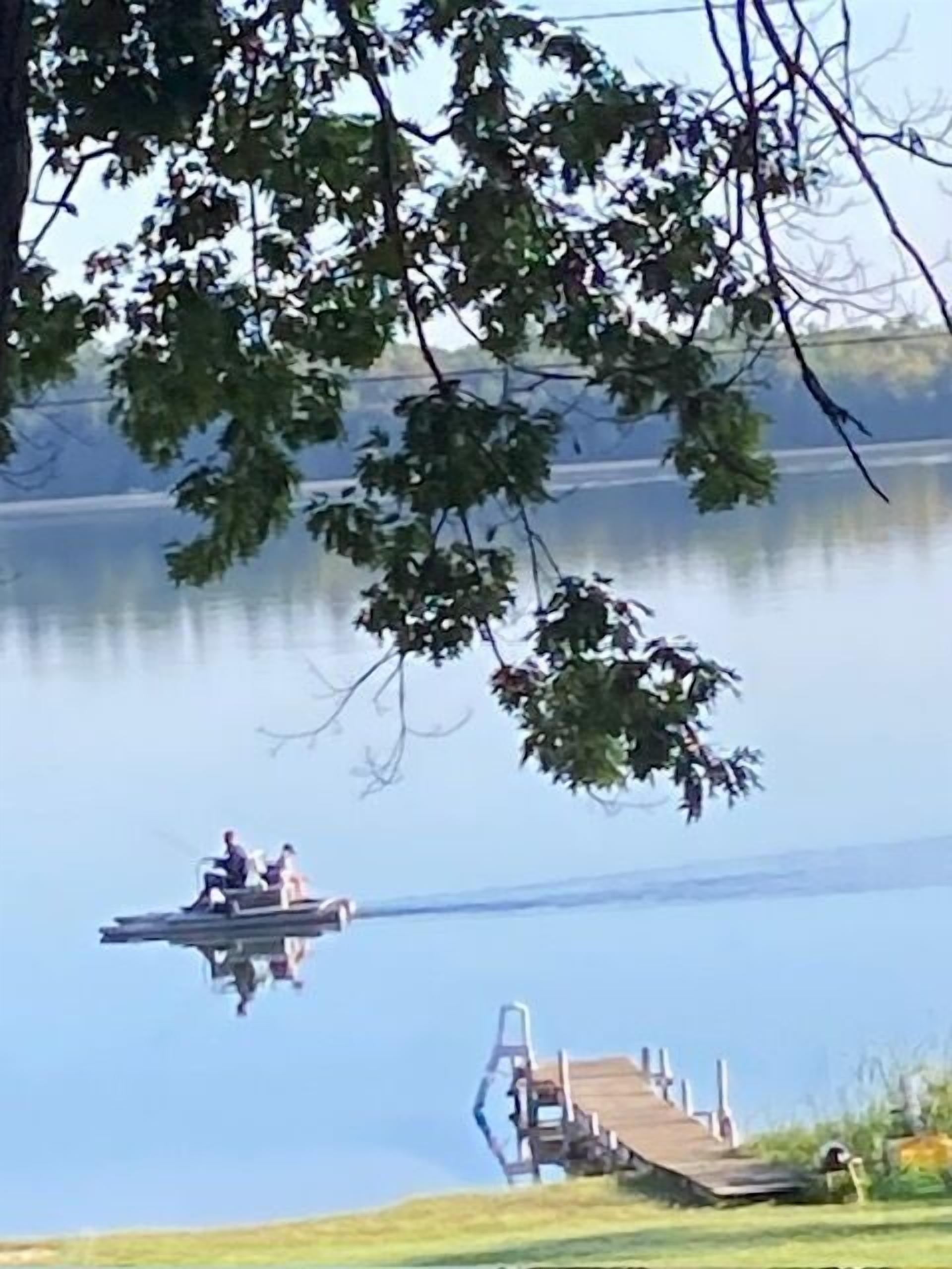Un lago tranquilo con un muelle que se adentra en el agua.