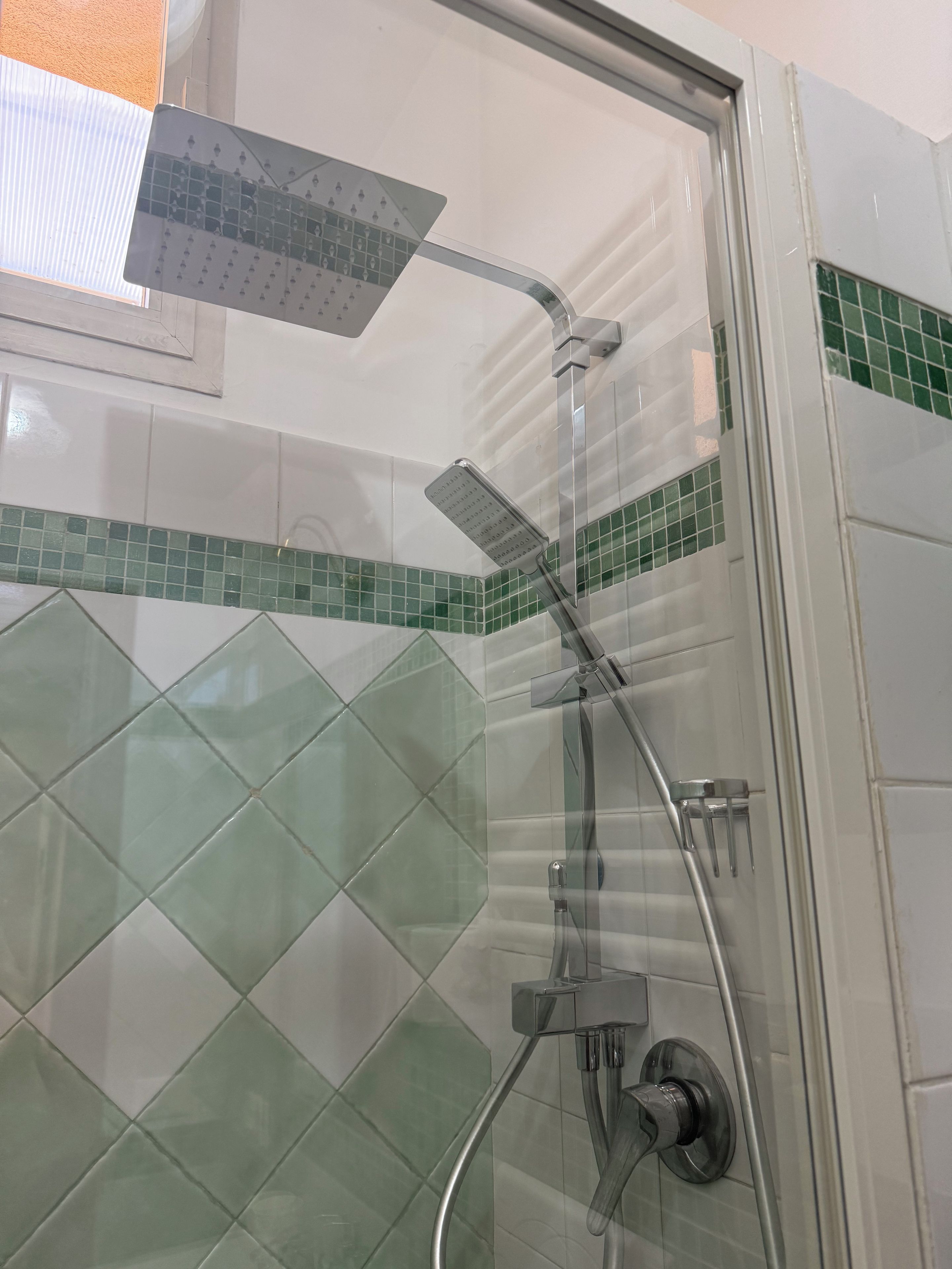 Ducha con cabezal de ducha de mano y grifo empotrado.