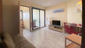 A spacious living area with a sofa, a TV, and a dining table. - Charming T2 for 4 people terrace sea view, elevator - 4CASI402 (CANET PLAGE)