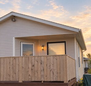 A single-story house with a covered porch, a window, and a door. - Little Haven Cottage - Ocean view 2 bedroom cottage with beach access. (Mount Stewart)