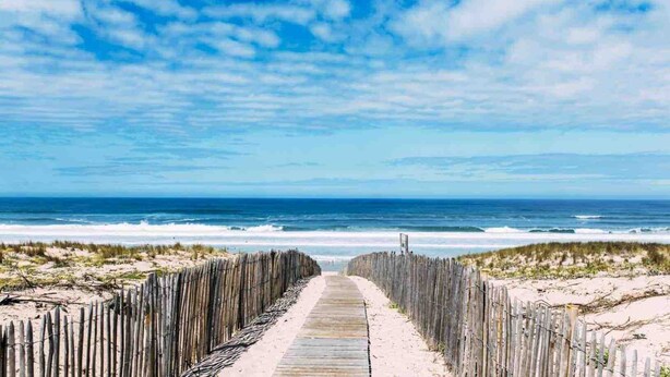 A wooden boardwalk leading to a beach with the ocean in the background. - Charming apartment ideally located - Swimming pool - Air conditioning (Mimizan)