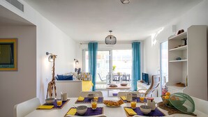 A dining area with a table set for breakfast, including bowls, glasses of orange juice, and a basket of oranges. - Charming apartment ideally located - Swimming pool - Air conditioning (Mimizan)
