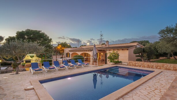 A swimming pool with lounge chairs, a stone patio, and a building with arches. - Villa "Sa Caseta Rustic Villa" with Pool, Terraces & Wi-Fi (Tourist Tax Included) (Cala D'or)