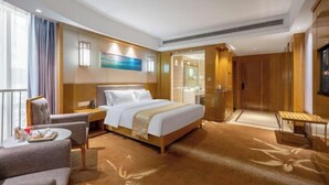 A modern hotel room with a large bed, a desk, a chair, and a small table. - Fusion International Hotel (Yizhang)