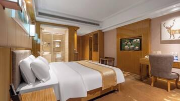Una habitación de hotel con una cama grande, un escritorio, una silla y un televisor.
