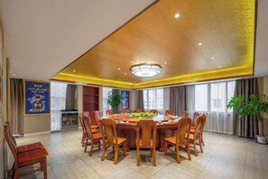 A conference room with a round table, chairs, and a ceiling light fixture. - Fusion International Hotel (Yizhang)