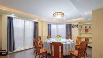 Un comedor con una mesa redonda, sillas y una araña.