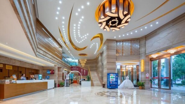 A spacious lobby with a reception desk, a staircase, and a vending machine. - Fusion International Hotel (Yizhang)
