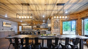 Una cocina moderna con una isla grande, techo de madera y vistas al exterior.