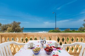 A table set with cups, a coffee pot, and bowls of fruit on a balcony overlooking the sea. - 3026 Villetta Lelia by Barbarhouse (Racale)