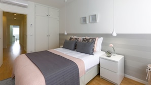 Una camera da letto con un letto, comodini, un armadio e una lampada a sospensione.