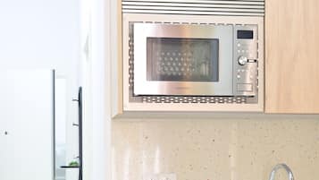 A modern kitchen with a stainless steel microwave, a coffee maker, and a dishwasher.