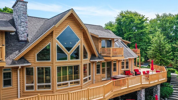 Ein großes Holzhaus mit mehreren Balkonen, großen Fenstern und Außenbereichen mit Sitzgelegenheiten.