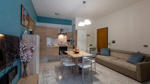 A modern kitchen with a dining area, a sofa, and a TV. - 2517 Villetta Lido La Pineta by Barbarhouse (Gallipoli)