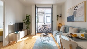 A modern living room with a TV, sofa, dining table, and balcony. - Sweet Flat 4Two in City Center w/ Balcony & Air Conditioning (Porto)