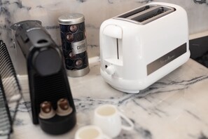 Enjoy a morning coffee at the kitchen counter with a coffee maker, toaster, and two cups.