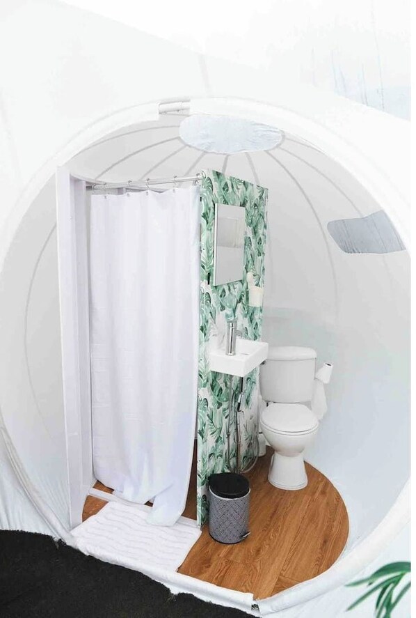 A circular room with a toilet, sink, and shower curtain. - Bubble Room with a View, Jacuzzi Spa, Kitchen (Toa Alta)