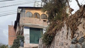 Gradians de pedra que condueixen a un edifici amb una entrada amb persianes verdes.