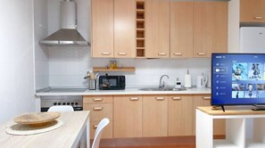 Enjoy cooking in this well-equipped kitchen with a range hood, microwave, sink, and coffee maker.