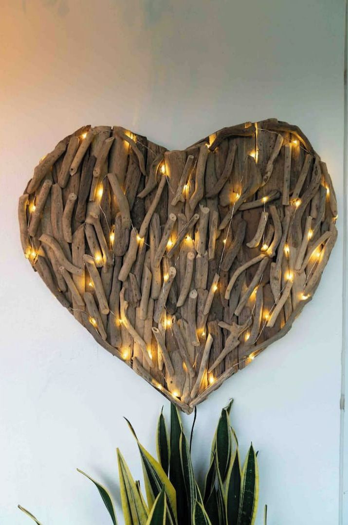 A heart-shaped wall decoration made of wood and string lights.