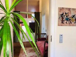 A room with a bed, a chair, a painting, and a plant. - Inviting 3-bed Villa Apartment in Bad Kreuznach (Bad Kreuznach)