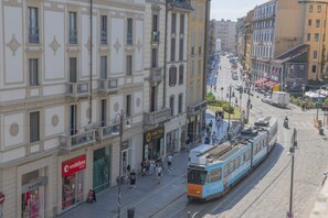 Un tramway circule dans une rue de la ville, avec des immeubles de chaque côté.