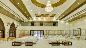 Un amplio salón con asientos escalonados, candelabros y un techo alto.