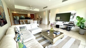 A modern living room with a sectional sofa, a coffee table, and a flat-screen TV. - Exclusive golf course view apartment in Buenaventura Golf & (El Chirú)