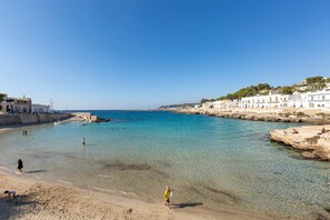 A coastal town with clear waters, a sandy beach, and white buildings along the shore. - 2141 Villetta Roberta - Piano Terra by Barbarhouse (Nardò)