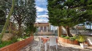 A patio with a table and chairs, surrounded by potted plants and a stone-tiled floor. - 2141 Villetta Roberta - Piano Terra by Barbarhouse (Nardò)