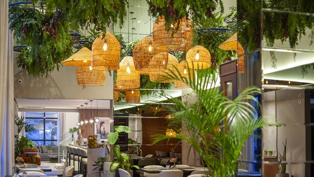 A modern interior with hanging wicker lamps, indoor plants, and a bar area. - Tri Hotel Premium Itapema (Itapema)