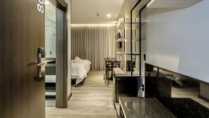 A modern hotel room with a bed, a desk, and a kitchenette. - Tri Hotel Premium Itapema (Itapema)
