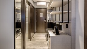 A modern hotel corridor with built-in shelves, a coffee machine, and a door with a sign. - Tri Hotel Premium Itapema (Itapema)
