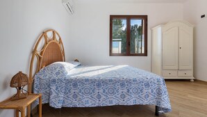 A bedroom with a bed, a wardrobe, a window, and a lamp. - 2142 Villetta Roberta - Primo Piano by Barbarhouse (Nardò)