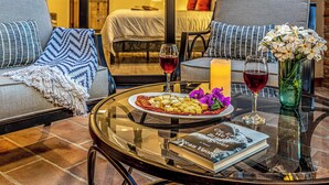 A dining area with a glass table, a plate of food, a book, and a vase of flowers.