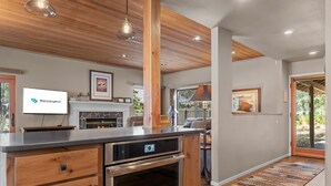 Una cocina moderna con armarios de madera, electrodomésticos de acero inoxidable y horno empotrado.
