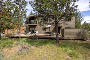 A modern two-story house with a balcony, outdoor seating area, and a covered patio. - DIXI02 - Great Home, AC, Dog Friendly, Hot Tub (Sunriver)