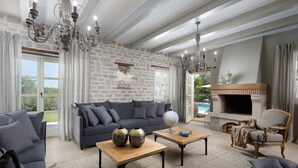 A spacious living room with a stone wall, a fireplace, and a pool view. - Villa for 8 persons, pool, tennis court, outdoor fitness (Ladići)