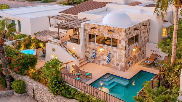 A modern villa with a swimming pool, outdoor seating, and a stone facade. - Charming Cabo Villa w/ Heated Pool, Hot Tub, Firepit, Palapa & Ocean Views (Cabo San Lucas)