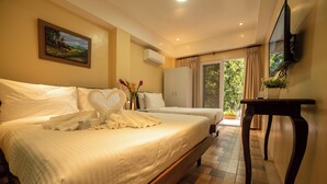 A hotel room with a large bed, a TV mounted on the wall, and a window with curtains. - Bernardos Lantia Hotel (Basco)