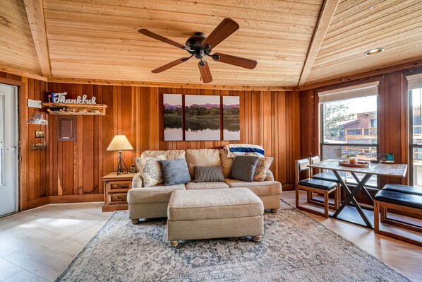 Relax in this inviting living room with a sofa set, dining table, and large window offering a view of the surrounding area.