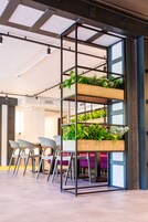 Un interior moderno con una estantería jardín vertical, zona de estar y una escalera a la vista.