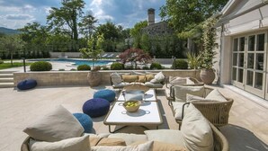 An outdoor patio area with wicker furniture, a pool, and a stone building in the background. - Luxuriously decorated villa with designer interior, pool, sauna and wellness (Pićan)