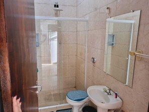 A bathroom with a shower, toilet, sink, and mirror. - Apartamento completo (Guaratingueta)