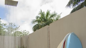 Two surfboards leaning against a wall in a garden area with a water feature. - Perfectly located in Playa Guiones. Walk to the beach, shops, restaurants & yoga (Nosara)