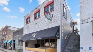 A building with a storefront labeled "Vine Shop - Fine Foods - Gourmet Grocery - Craft Beer".