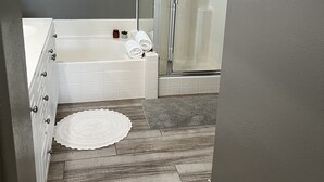 A bathroom with a bathtub, a shower, and a walk-in shower.