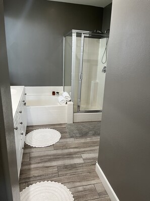 A bathroom with a bathtub, a shower, and a walk-in shower.