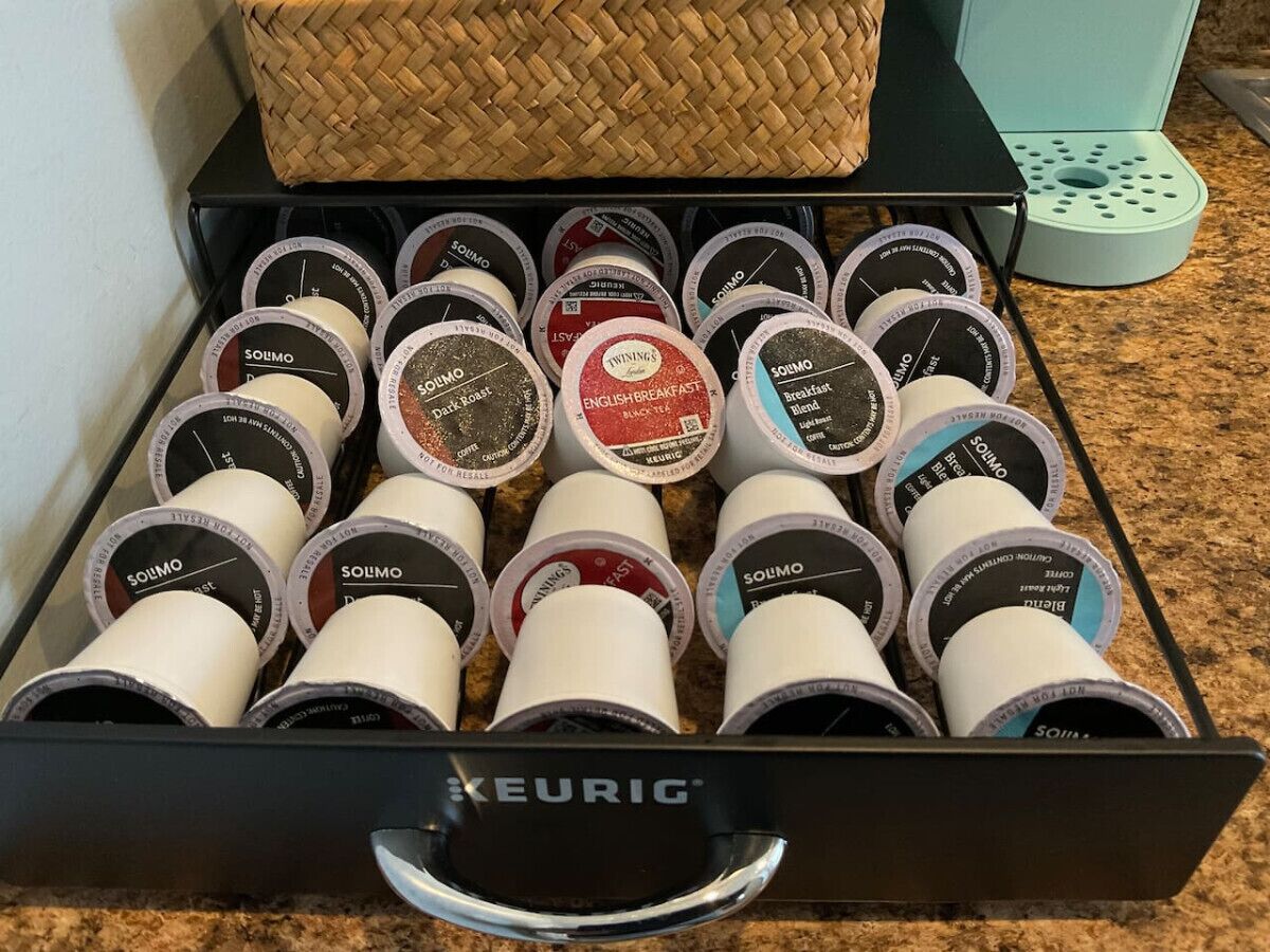A drawer filled with various coffee pods labeled 'Solmo' and 'Twinnings'.