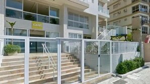 Un immeuble à plusieurs étages, doté d’une entrée en verre et d’un escalier menant au rez-de-chaussée.